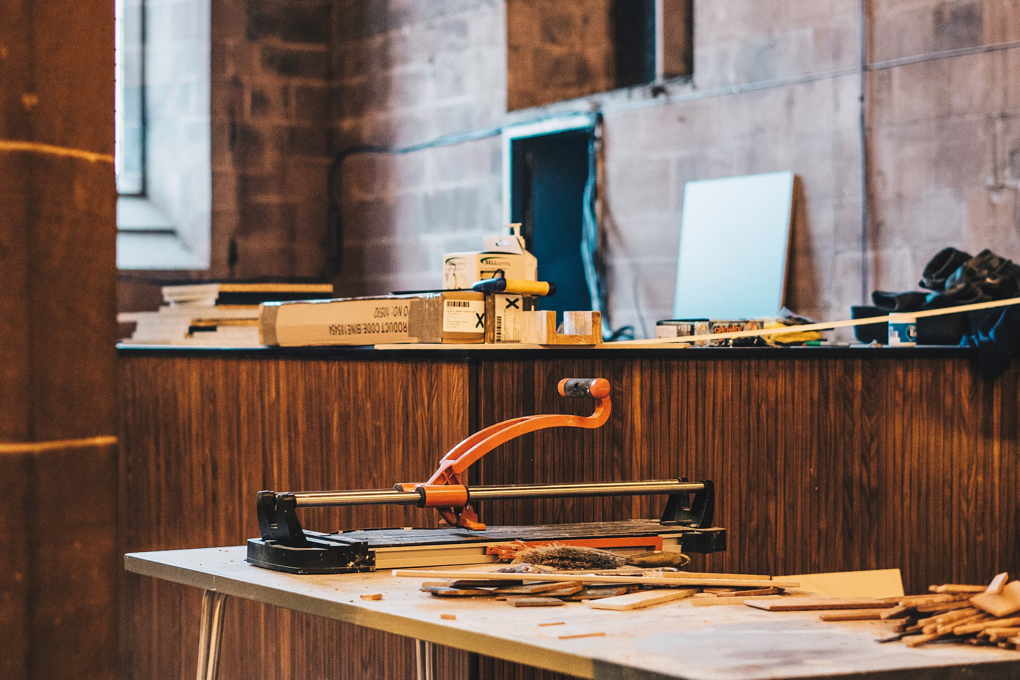 Workshop table with tools and drill representing joinery and fabrication